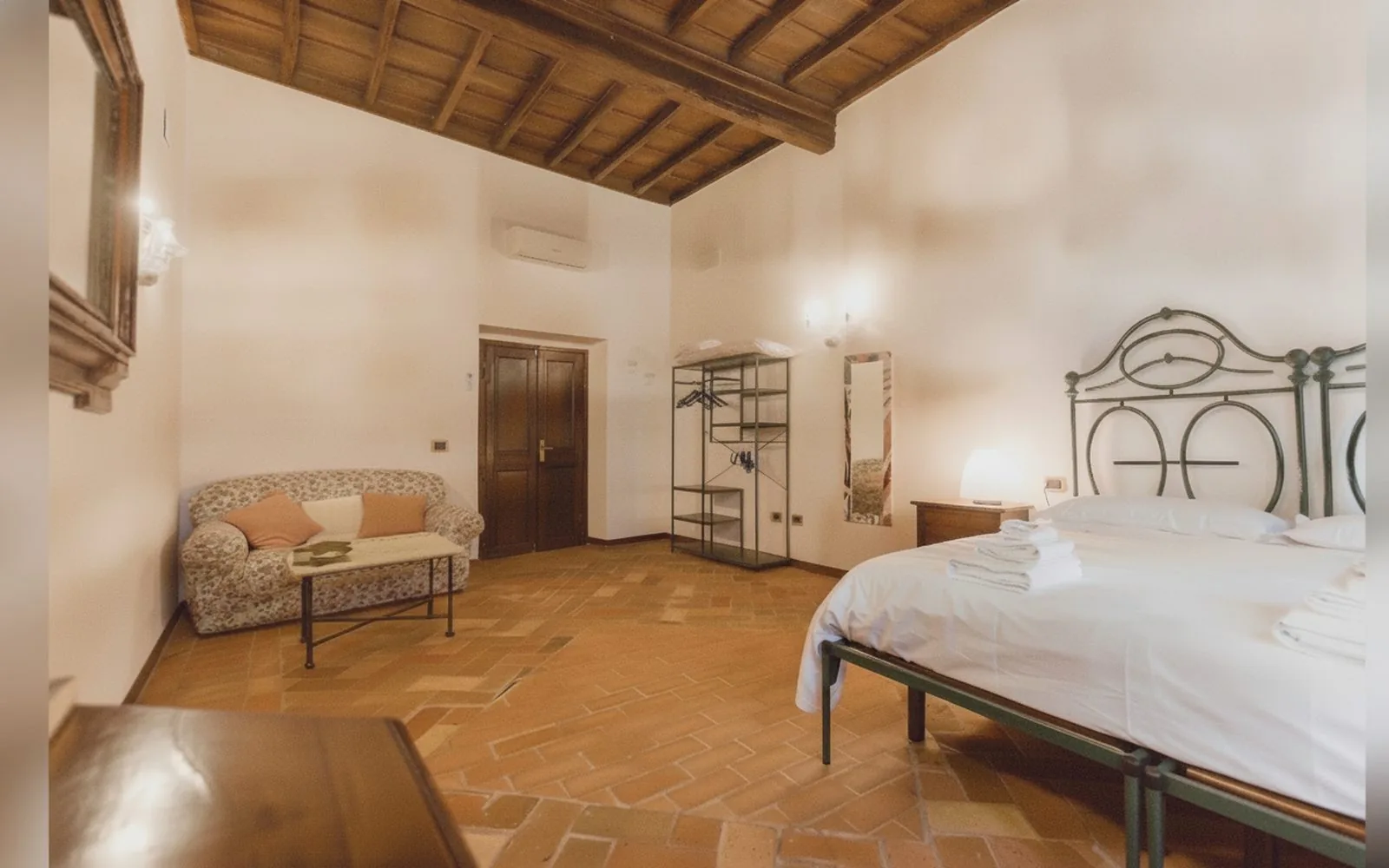 Camera matrimoniale con divanetto e letto in ferro battuto