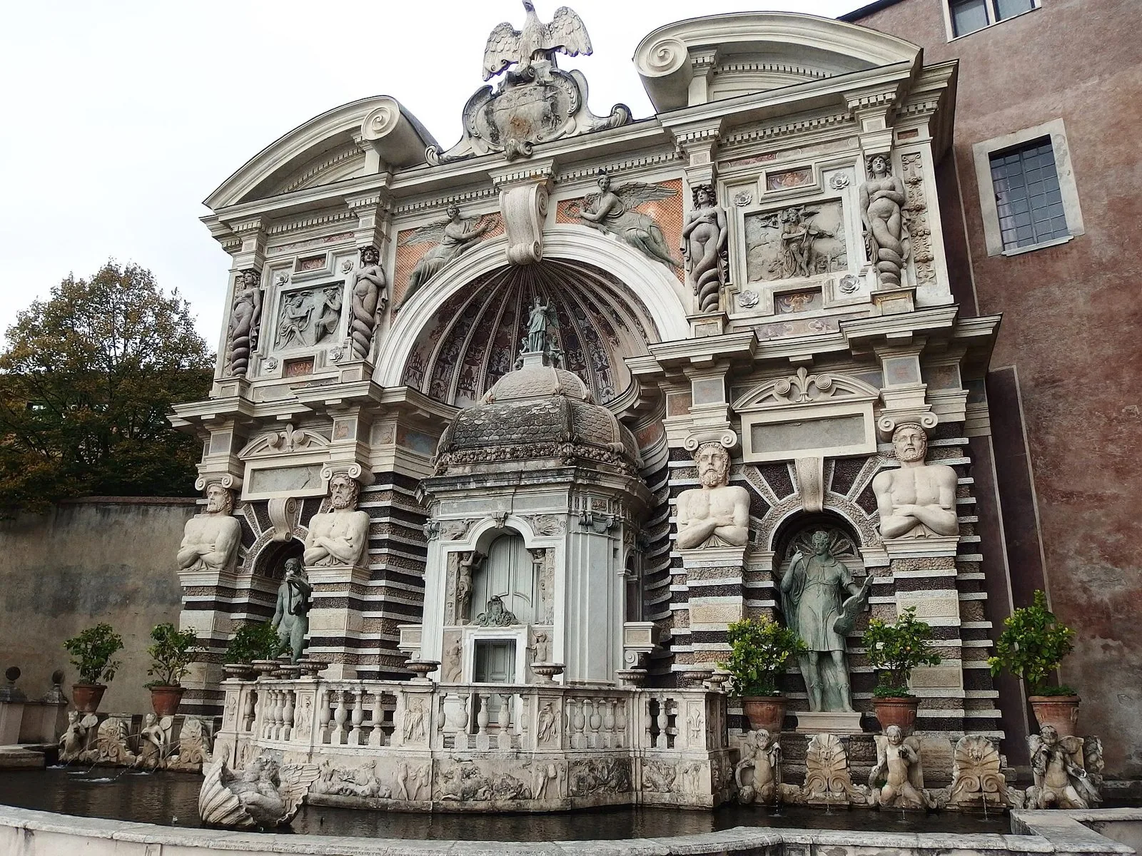 La facciata monumentale della Fontana dell'Organo a Villa d'Este, con statue, telamoni e la vasca in primo piano